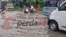 Kondisi jalan rusak parah di jalur lintas Perdagangan – Pematang Siantar yang digenangi air dan lumpur.
