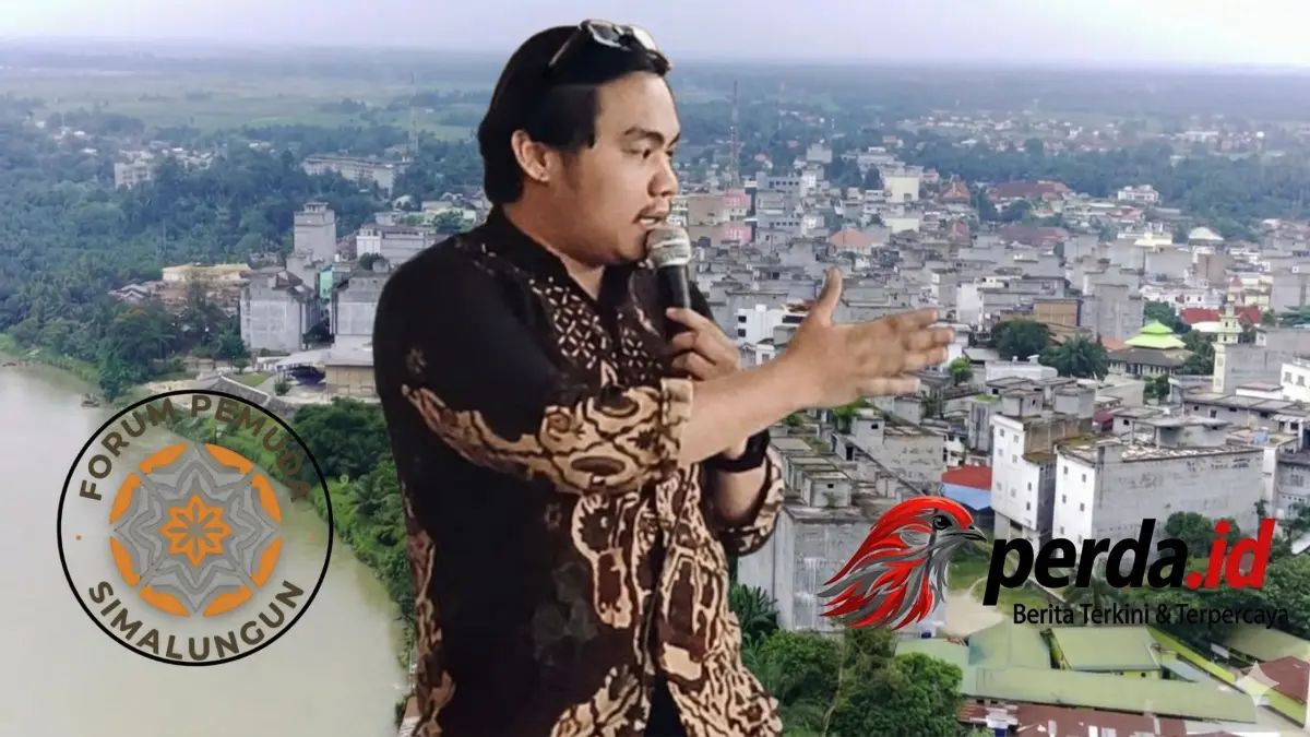 Koordinator Forum Pemuda Simalungun berbaju batik memberikan pernyataan sikap menggunakan mikrofon dengan latar belakang polos.
