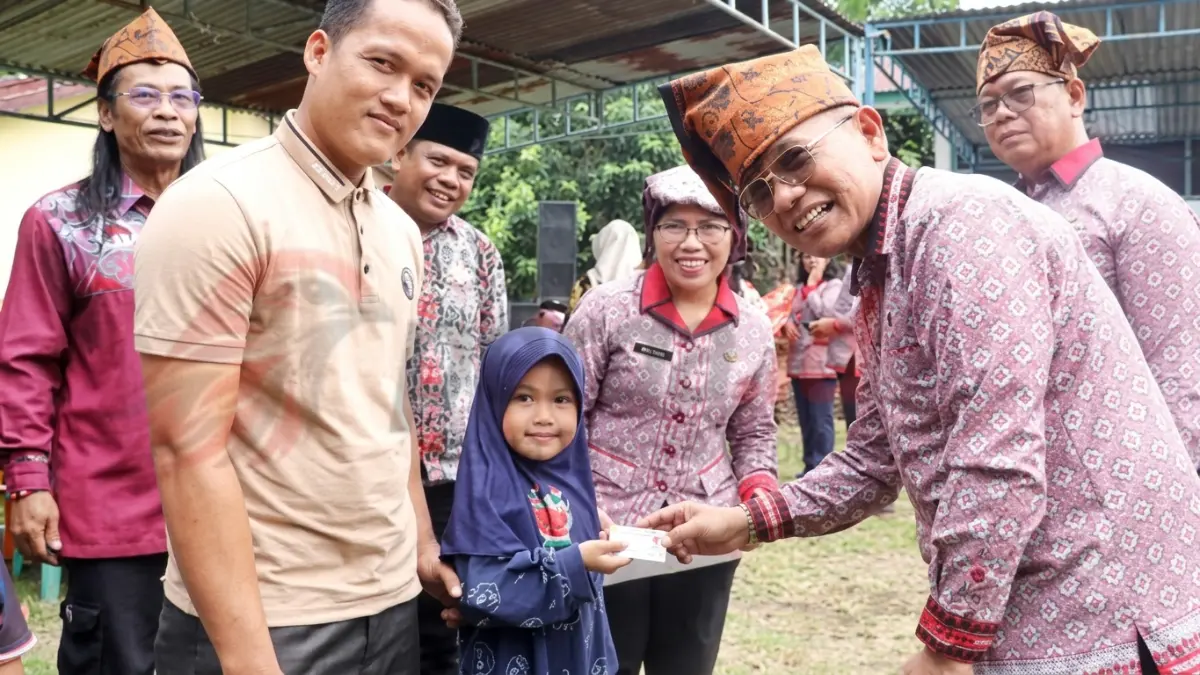 Bupati Simalungun Anton Achmad Saragih menyerahkan dokumen kependudukan kepada warga dalam kegiatan pelayanan terpadu di Nagori Pematang Gajing.