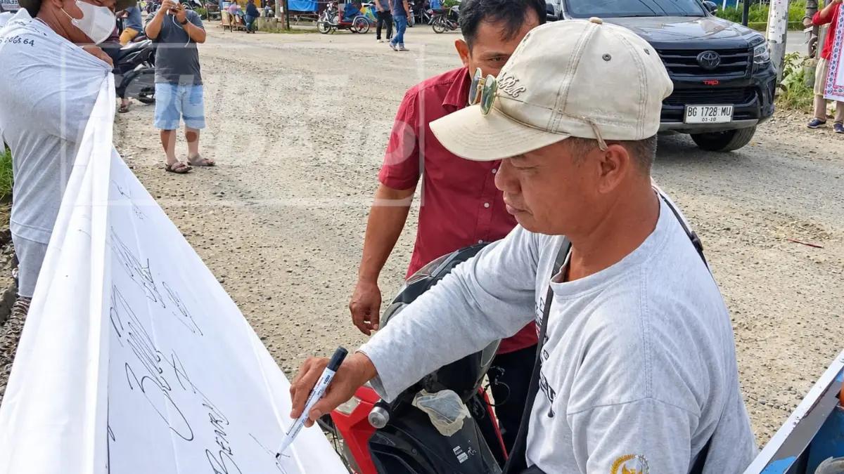 Warga membubuhkan tanda tangan mendukung pemekaran Simalungun Hataran dalam aksi GESTURS di Kecamatan Bandar Salin
